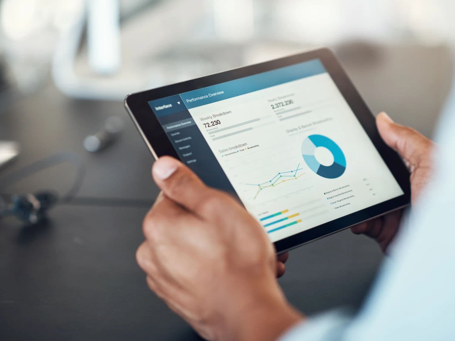 Person holding tablet showing investment data