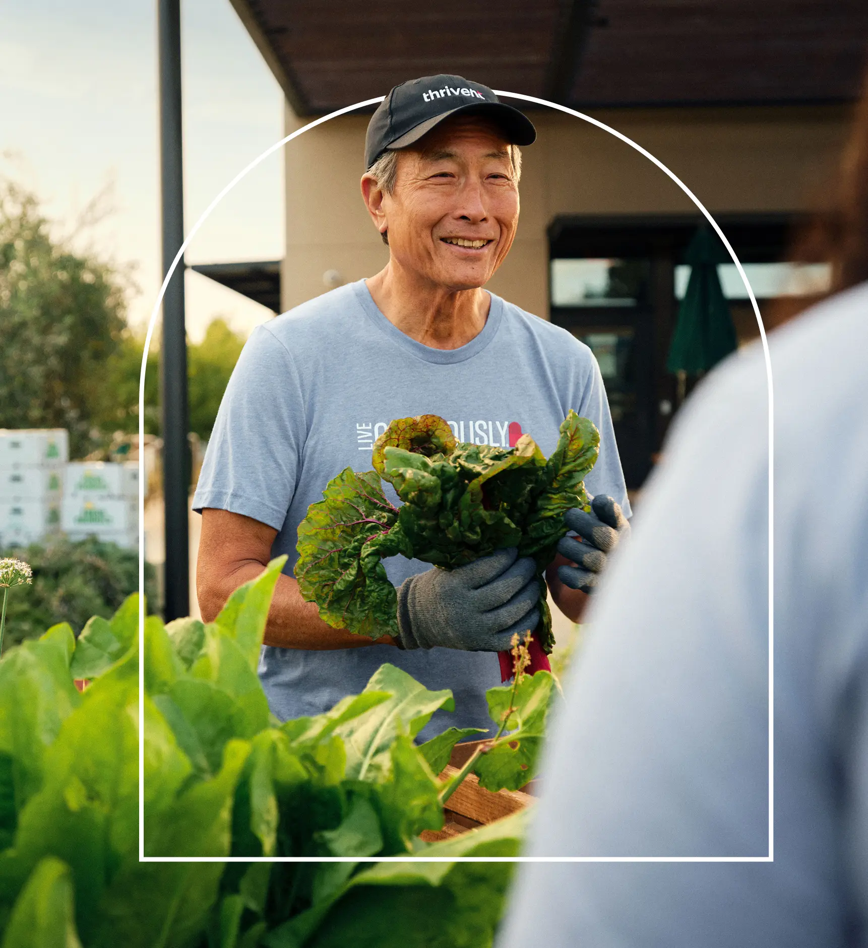 Man wearing Thrivent hat and shirt holding produce