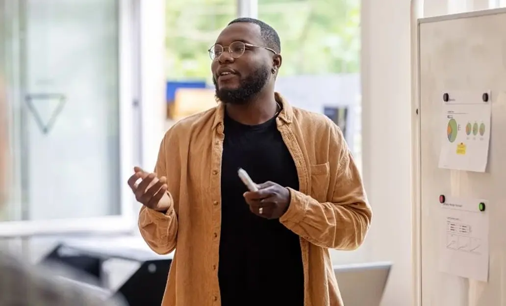 Man talking while standing in front of a white board