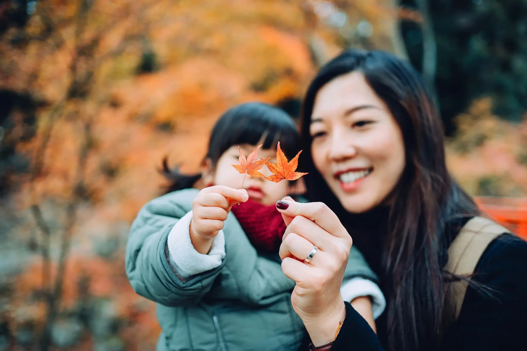 Mother holding son and looking at leaf